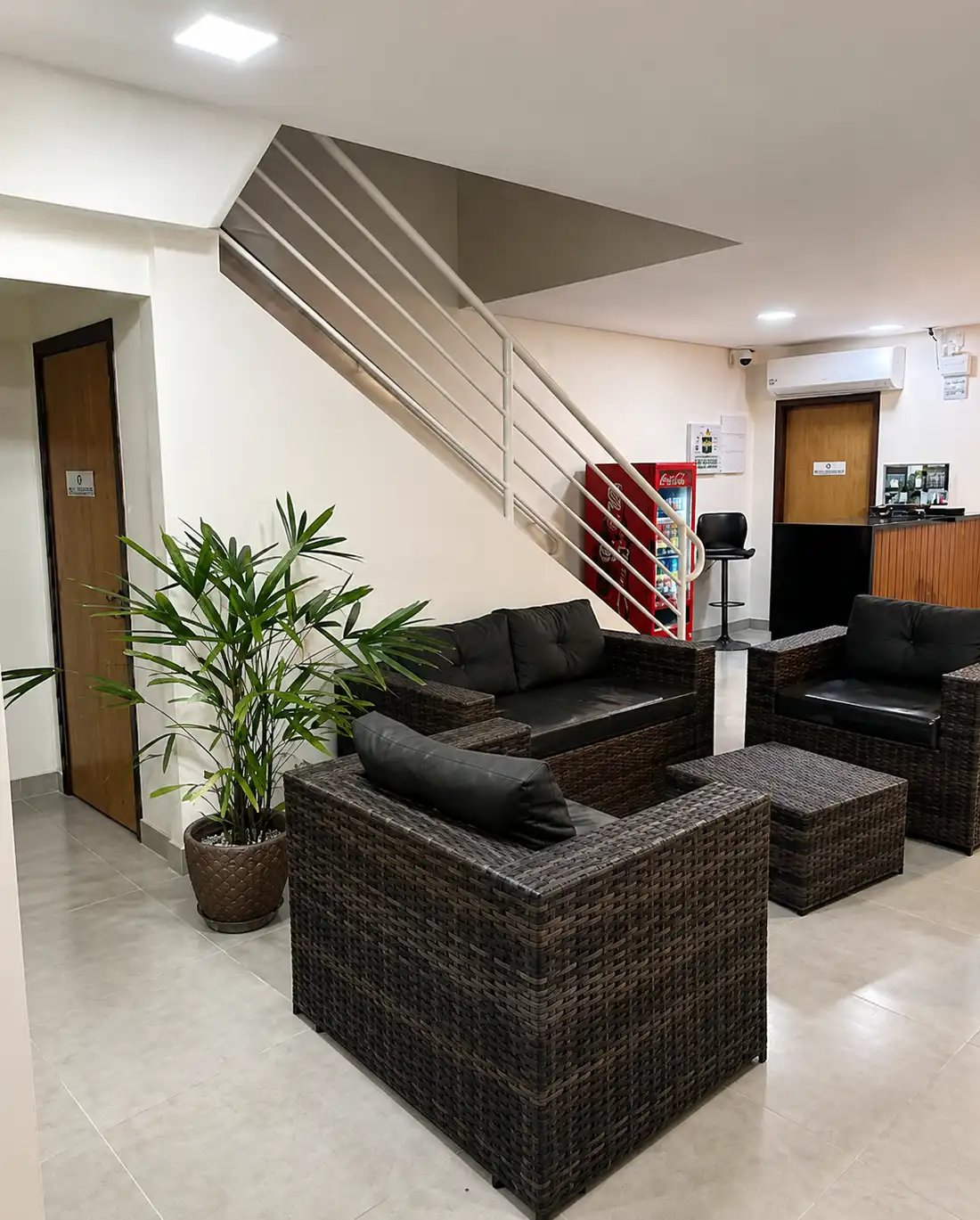 Poltronas da sala de estar ao lado da escada e da recepção